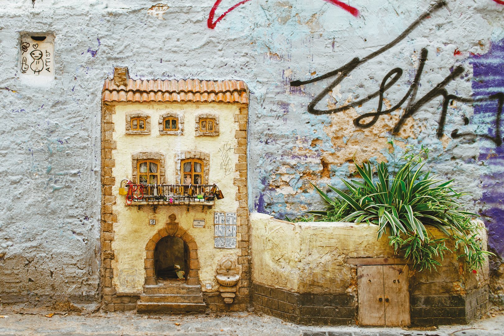 a tiny house carved into a wall in Valencia